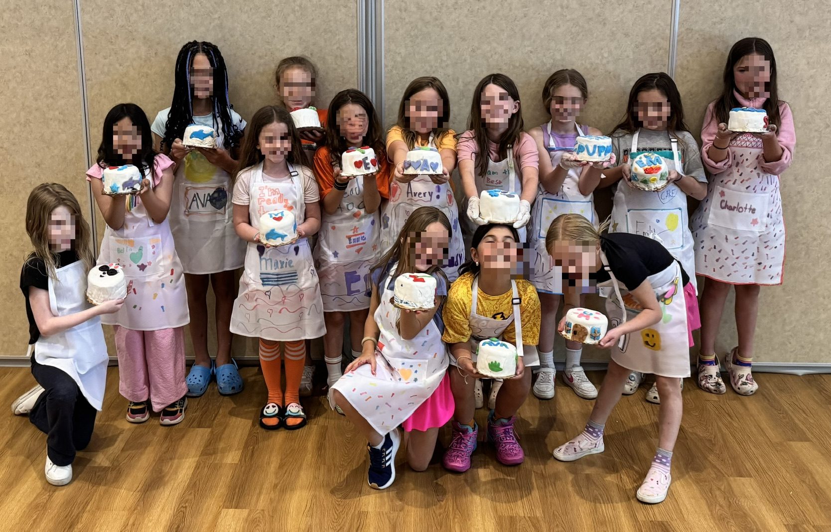 Kids' cake decorating class showing off their cakes