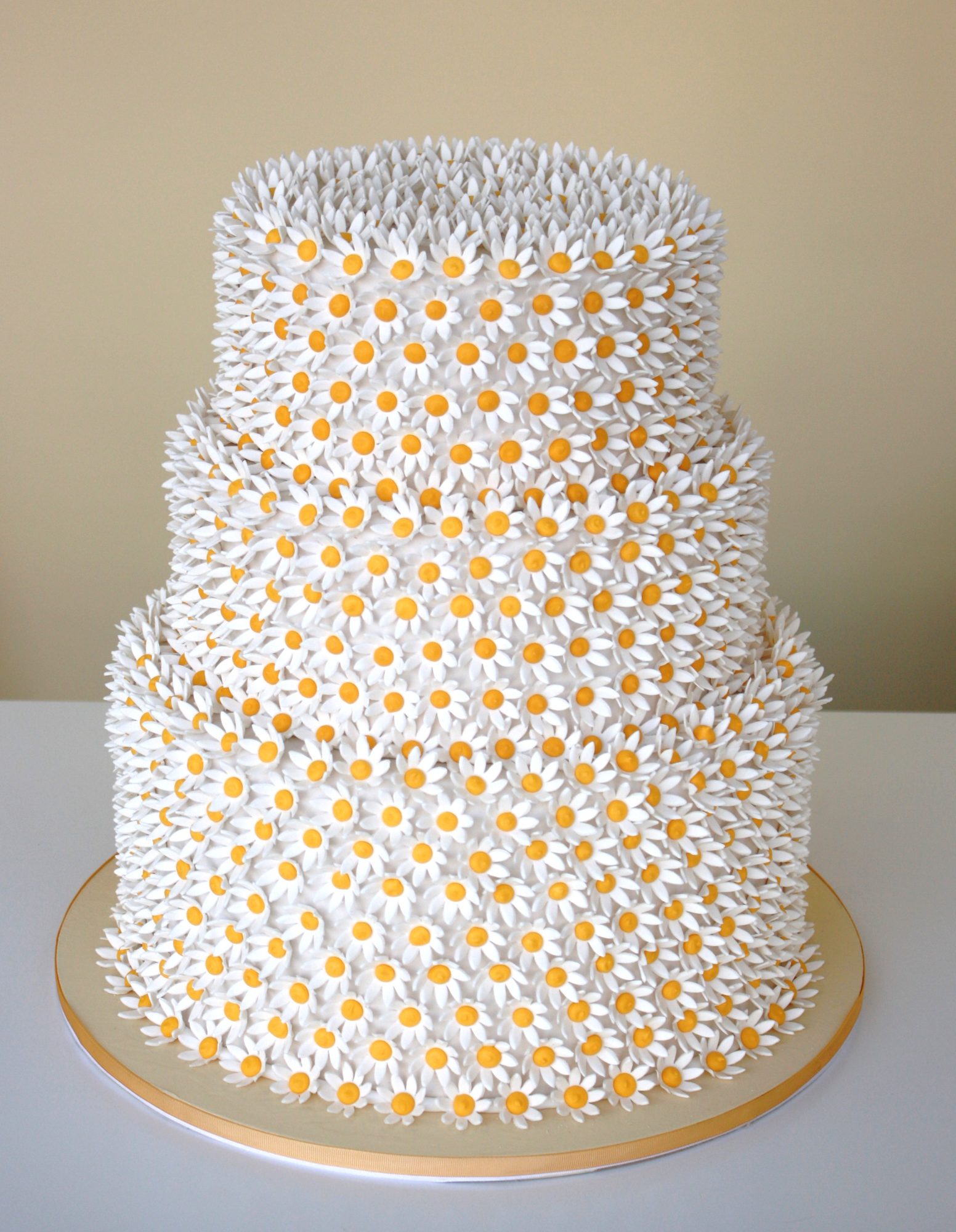 Wedding cake covered in sugar daisies