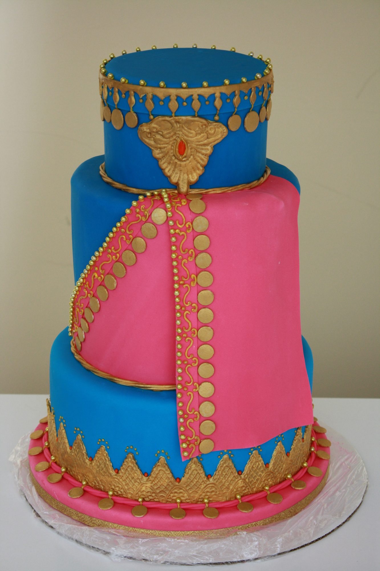 Ornate wedding cake in blue, pink and gold