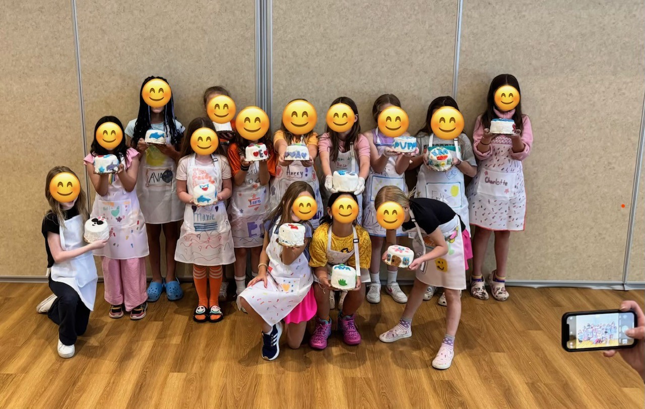 Kids showing off their decorated cakes after a cake class