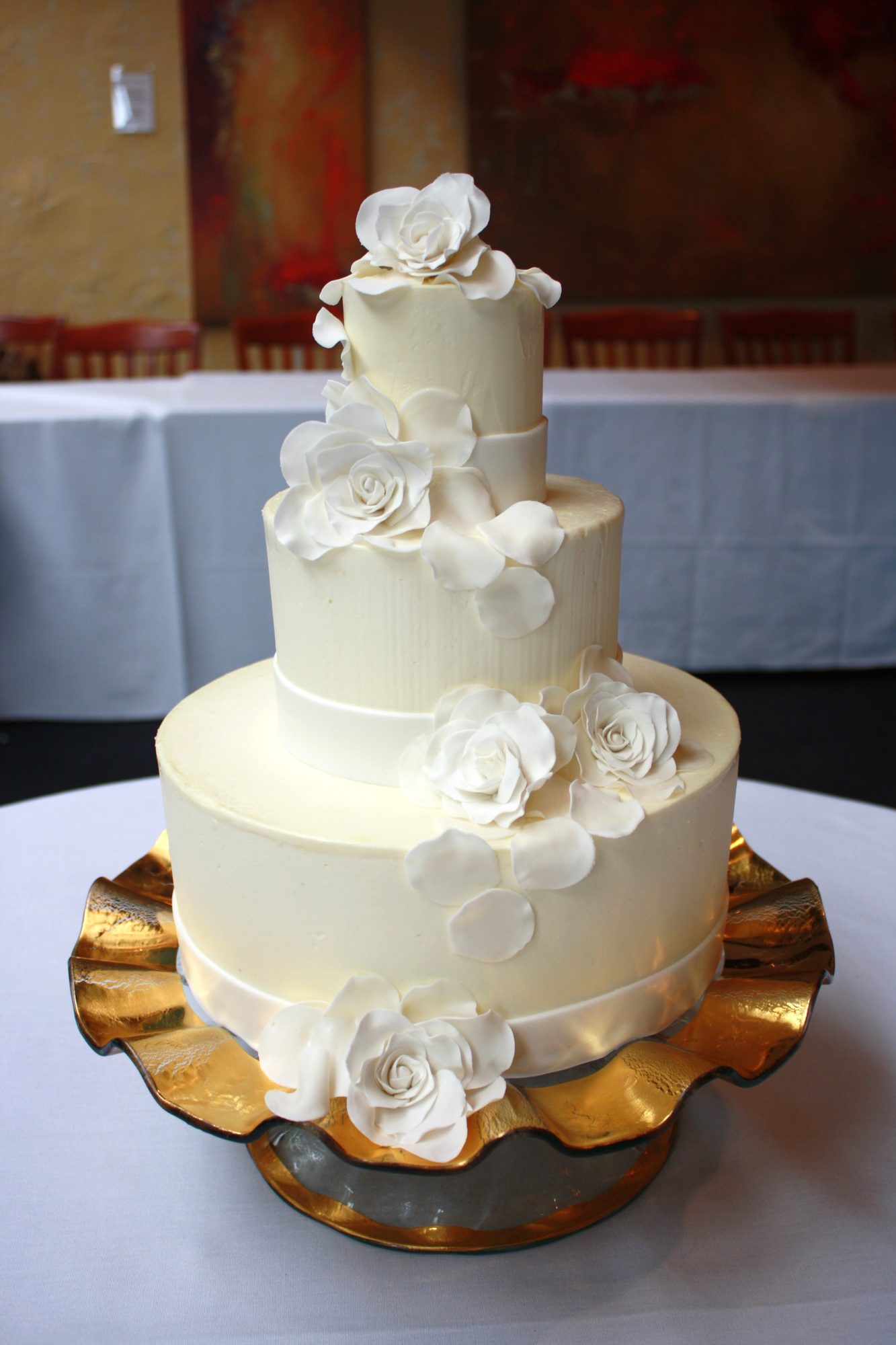 Wedding cake with sugar roses on a gold stand