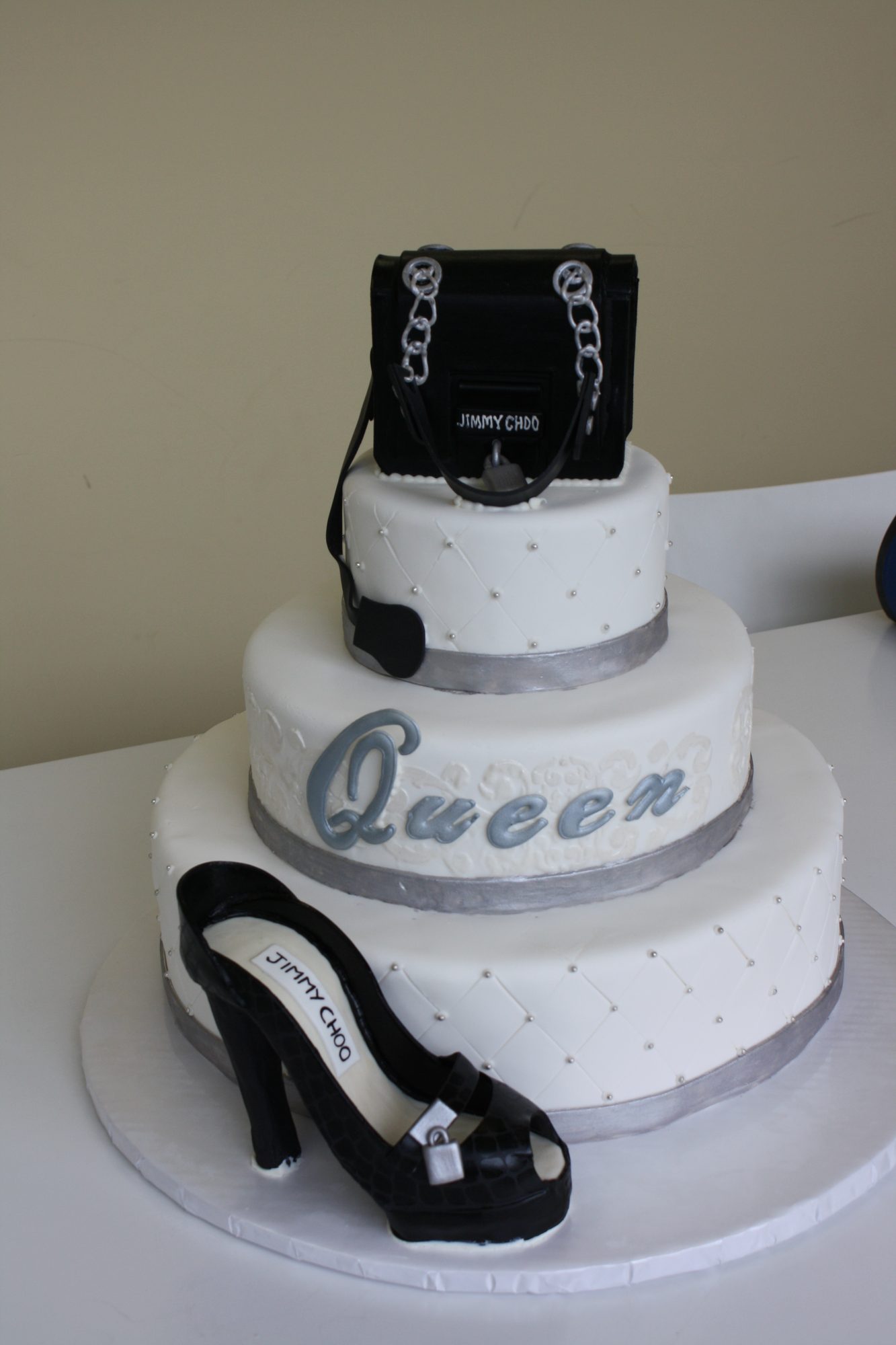 Three-tier birthday cake with a designer handbag and black heel